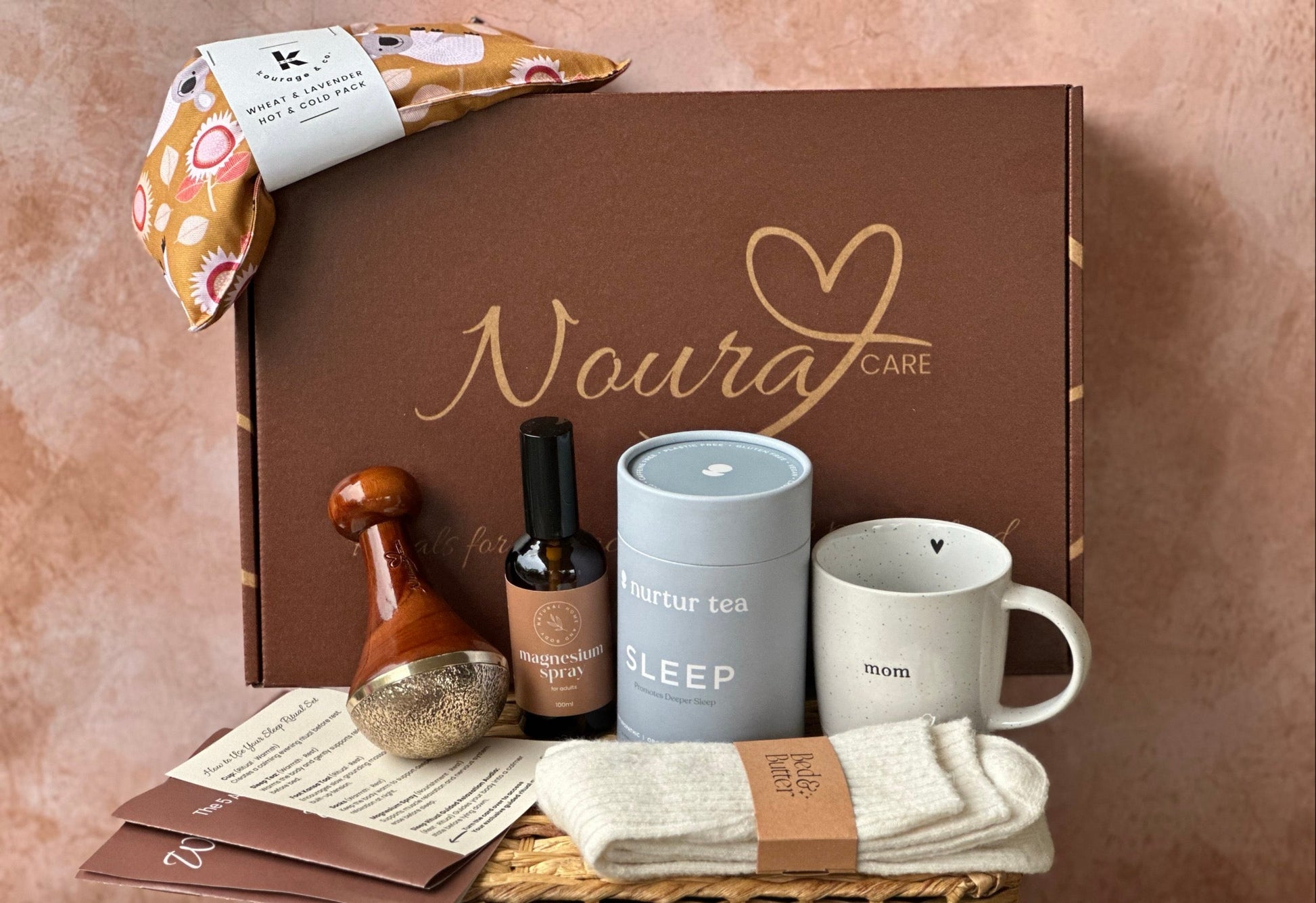 Noura Care product set including a mug, candle, and other items on a textured surface.